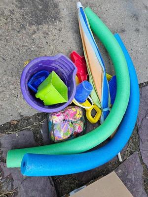 Beach toys with bucket - water noodles - and an umbrella