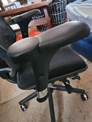 Adjustable ergonomic office chair with old school steel trash can