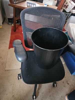 Adjustable ergonomic office chair with old school steel trash can