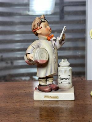 GOEBEL HUMMEL "LITTLE PHARMACIST" AND WALKER POTTERY FIGURINES