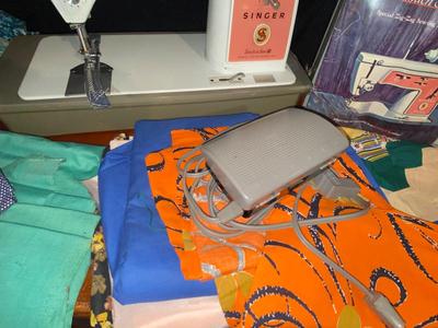SINGER, SEWING MACHINE IN A VARIETY. OF VINTAGE MATERIAL