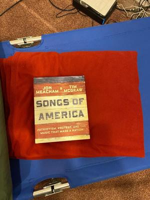 BOW, SLEEPING COT, WOOL BLANKET, FLEECE BLANKET, INFLATABLE SLEEPING PAD, AND A SONG BOOK FOR SINGING WHILE YOU CAMP!