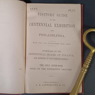 LOT 195: 1876 Philadelphia Centennial Exhibition Visitors Guide w/ Brass Eagle Flag Topper, Bailey Banks & Biddle Co. Miniature...