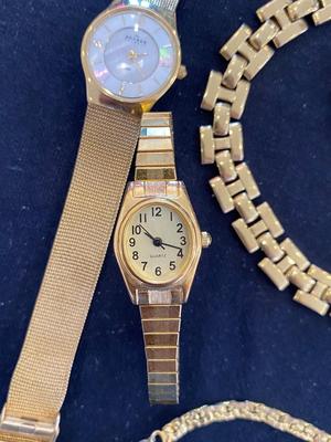 A VARIETY OF GOLD TONE WATCHES, JEWELRY AND A BELT BUCKLE