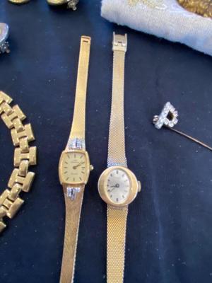 A VARIETY OF GOLD TONE WATCHES, JEWELRY AND A BELT BUCKLE