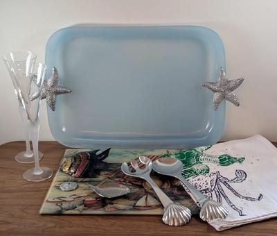 LOT 55K: Beach Themed Collection, 2 Fluted Champagne Glasses, Serving Tray, Utensils, Glass Cutting Board, Kitchen Towels And Whimsical...