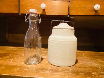 ANTIQUE MILK BOTTLE AND GLAZED STONEWARE JAR WITH LOCKING LID