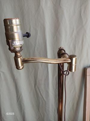 Antique highback diningroom chair with a brass colored swing arm floor lamp