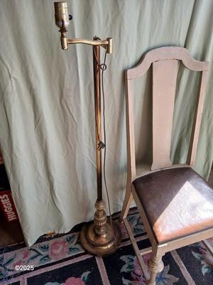 Antique highback diningroom chair with a brass colored swing arm floor lamp