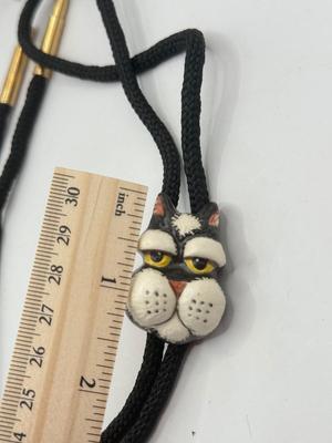 LOT 190J: Two Painted Clay Cat Bolo Ties