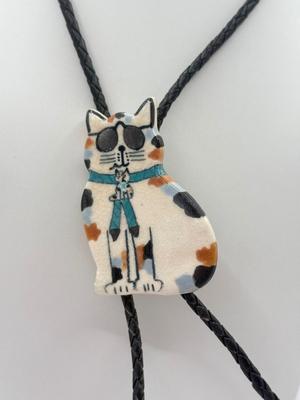 LOT 190J: Two Painted Clay Cat Bolo Ties