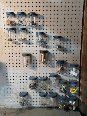 Pegboard mounted lidded containers with hardware