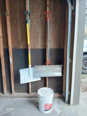 Two snow shovels - one metal - one plastic and a lidded bucket for ice melt