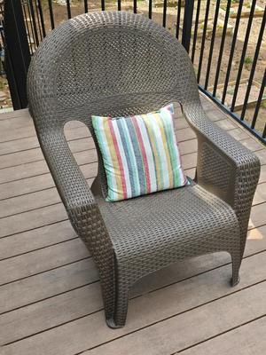 Faux wicker woven patio chair with outdoor throw pillow