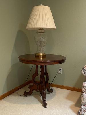 ANTIQUE WALNUT SIDE TABLE ON CASTERS AND A LEAD CRYSTAL CUT LAMP