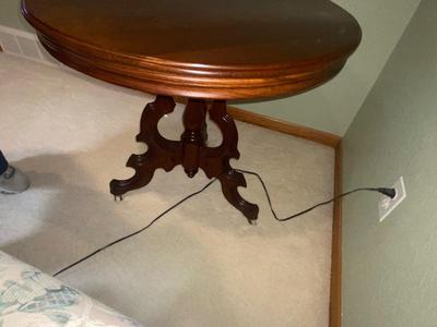 ANTIQUE WALNUT SIDE TABLE ON CASTERS AND A LEAD CRYSTAL CUT LAMP