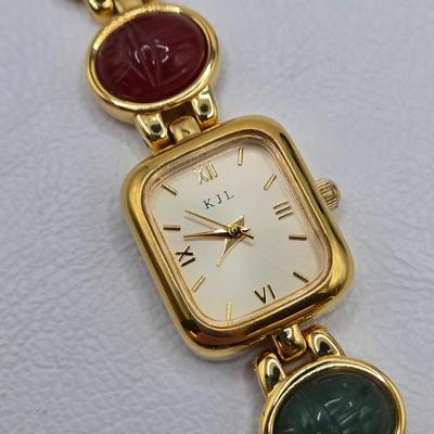 LOT 25: Gold-tone Cuff Bracelet, Gold-tone Spring Open Bracelet w/ Amber Colored Gems, and Kenneth Jay Lane Scarab Gemstone Watch