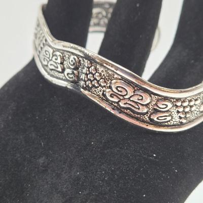 LOT 27: Three Silver-tone Cuff Bracelets and one Magnetic Closure Braided Rope-like Bracelet