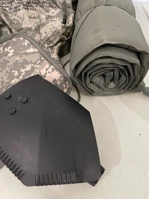 Two wet weather, ponchos, shovel, bag, and sleeping mat