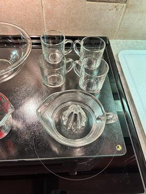 CLEAR GLASS KITCHEN MEASURING CUP, JUICER, JUICE GLASSES, MIXING BOWL, AND CUTTING BOARD