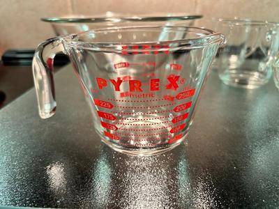 CLEAR GLASS KITCHEN MEASURING CUP, JUICER, JUICE GLASSES, MIXING BOWL, AND CUTTING BOARD