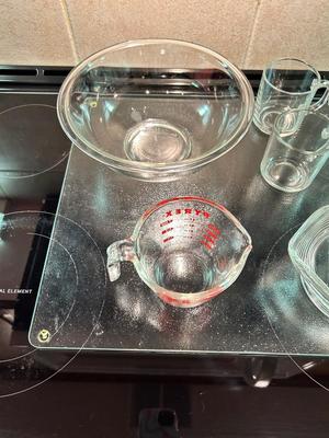 CLEAR GLASS KITCHEN MEASURING CUP, JUICER, JUICE GLASSES, MIXING BOWL, AND CUTTING BOARD