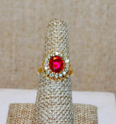 Size 6½ Nice Red Oval Center Stone Ring with Glitter Clear Stones Surround on a "Nest" Setting & Gold Tone Band (5.4g)