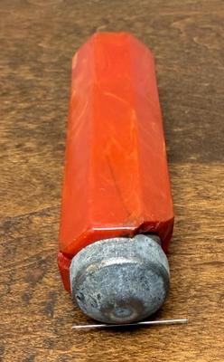 Sale Photo Thumbnail #253: Strong magnet for holding or pulling bobby pins, covered in what appears to be marbled red bakelite.    Bakelite is damaged, with a long split on one side a a section broken off near the magnetic tip.  Could also be used in sewing to hold straight pins.