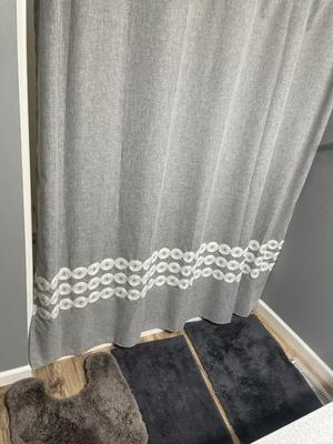 Gray shower curtain and three rugs