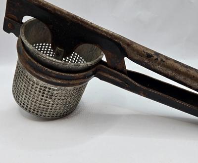 LOT 36: Vintage Kitchen Gadgets Including Hand Held Ice Crusher, Potato Masher, Cheese Graters, Can Opener, and More