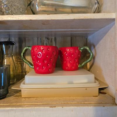 LOT 38: Kitchen Cabinet Lot: Tupperware Egg Tray, Avocado Green Napkin Holder & Salt/Pepper Shakers Strawberry Mugs, Glass Pie Pans,...