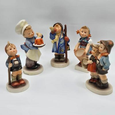 LOT 31D: Goebel Hummel Figurines Including Night Watchman, Little Pastry Cook, Little Hiker, Surprise AKA Hansel & Gretel, and Little...