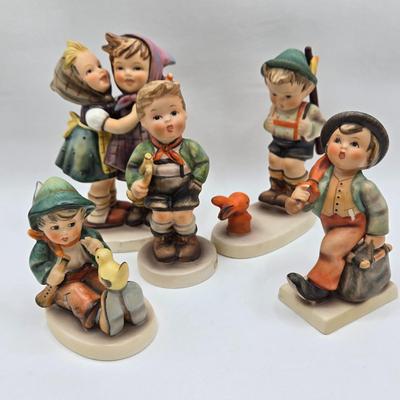 LOT 36D: Goebel Hummel Figurines Including Telling Her Secret, Trumpet Boy, Singing Lessons, Sensitive Hunter, and Merry Wanderer