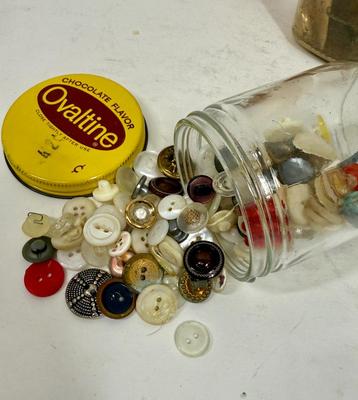 Sale Photo Thumbnail #236: The Buckles in the Bullock's paper bag are made of an early plastic. The Ovaltine glass jar has many small and unusual buttons. The Vaseline jar contains buttons that are seriously starting to decay, but might be salvaged.