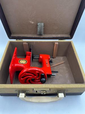 Sale Photo Thumbnail #377: Well built toy, made of cast iron.  Hand cranked sewing machine that produces a simple chain stitch.  Comes with original clamp, manual, spool and needle package but no needles inside.

Very collectible.