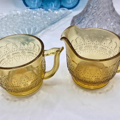 LOT 131: Blue Glass Deviled Egg Plate, Lace Edge Clear Glass Pedestal Bowl, Fan Plate, Green and Amber Glass Lace & Dew Drop Cream...