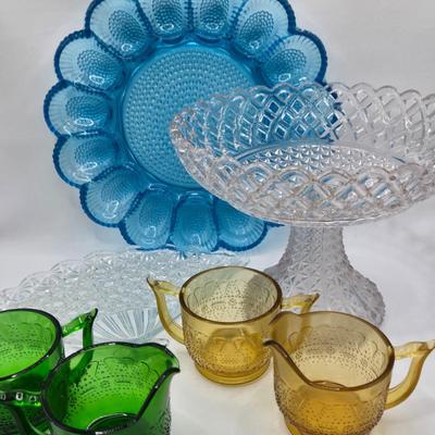 LOT 131: Blue Glass Deviled Egg Plate, Lace Edge Clear Glass Pedestal Bowl, Fan Plate, Green and Amber Glass Lace & Dew Drop Cream...