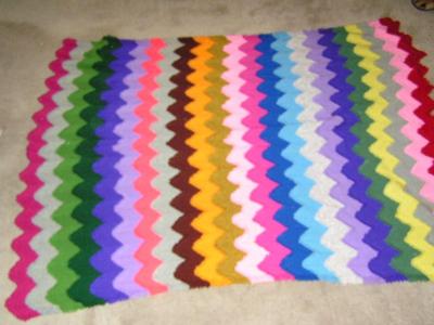 Knit afghan. Wavy stipes in a rainbow of colors. About 64"x83", good condition