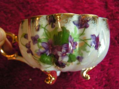Vintage Norcrest porcelain 3-footed teacup with saucer. Pearlescent finish