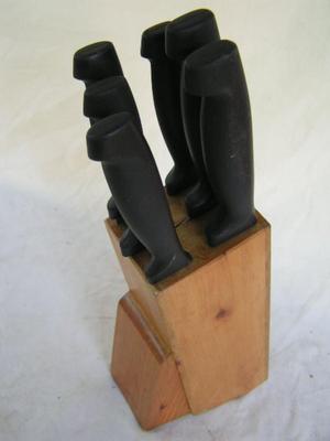 Six knives in a knife block.
