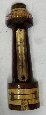 Sale Photo Thumbnail #102: Polished and stained wood lighthouse with brass and copper accents. Attached glass thermometer measures from 0 degrees C to 50 degrees C. Good condition, approx. 8" tall.