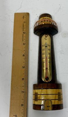 Sale Photo Thumbnail #103: Polished and stained wood lighthouse with brass and copper accents. Attached glass thermometer measures from 0 degrees C to 50 degrees C. Good condition, approx. 8" tall.