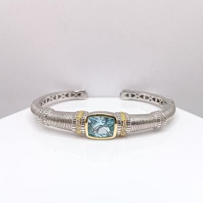 LOT 310: Judith Ripka 925 Sterling Silver and 18K Gold Cuff Bracelet with Blue Topaz Center