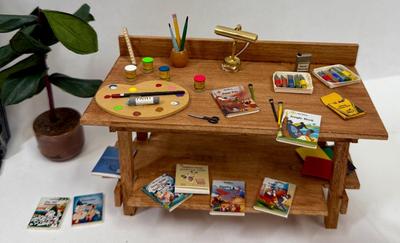 Sale Photo Thumbnail #330: Fireplace, 2 potted plants. brick patch, Miniaturized Disney Books, Miniaturized Disney Poster, Brass Light fixture on desk, scissors, brush, pencil, pain pallet, paint, chalk, crayons, newspapers etc