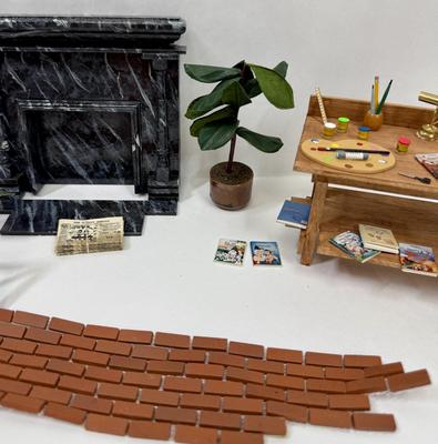 Sale Photo Thumbnail #331: Fireplace, 2 potted plants. brick patch, Miniaturized Disney Books, Miniaturized Disney Poster, Brass Light fixture on desk, scissors, brush, pencil, pain pallet, paint, chalk, crayons, newspapers etc