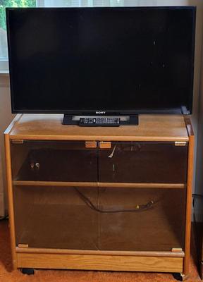 LOT 11B: Sony 32" TV and Remote with Glass Door Two Shelf Stand on Wheels