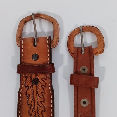LOT 195: Tony Lama Tooled Leather Acorn Belt, Braided and Tooled Leather Belt Made in Mexico & (2) Vintage Bolo Ties