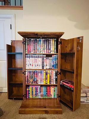 SEVERAL DISNEY MOVIES AND OTHER GREAT FAMILY MOVIES IN A NICE STORAGE CABINET