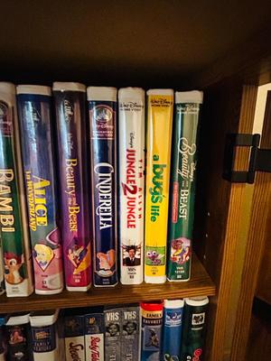 SEVERAL DISNEY MOVIES AND OTHER GREAT FAMILY MOVIES IN A NICE STORAGE CABINET