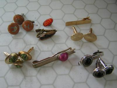 A collection of cuff links, tie bars/tacks